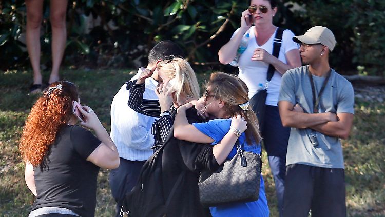 Angehörige im Schockzustand warten vor der Highschool von Parkland. 