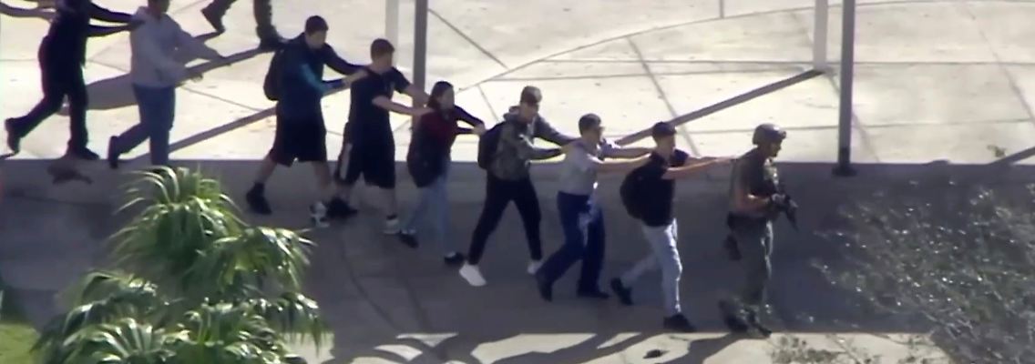 Diese Schüler werden von Sicherheitskräften aus der Schule geführt.
