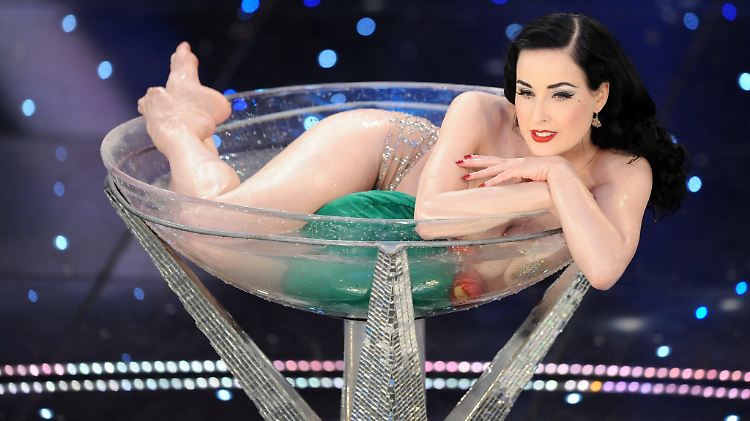 Tauscht das Glas gegen das Gesangsmikro - aber nur kurz: Dita von Teese.