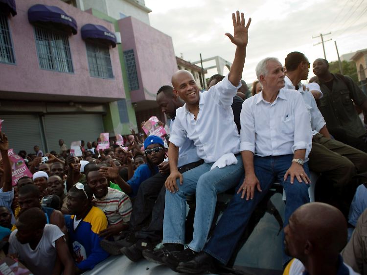Die unterlegenen Kandidaten Michel Martelly (Mitte) und Charles Henri Baker, unterstützt von US-Musiker Wyclef Jean (links außen) und tausenden Anhängern.