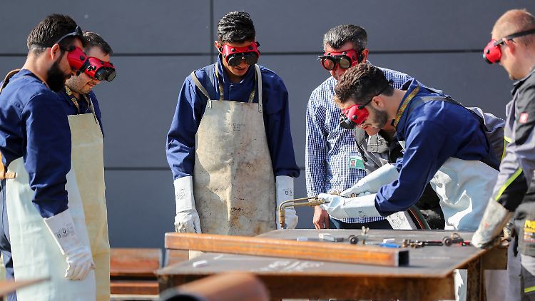 Flüchtlinge lernen in einem Ingolstädter Betrieb die Arbeit mit einem Schweißbrenner.