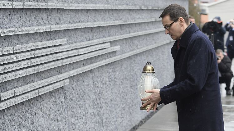Polens Ministerpräsident Mateusz Morawiecki legt eine Kerze an einer Gedenkmauer für die jüdischen Opfer des Zweiten Weltkrieges ab.