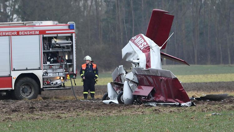 Ein Feuerwehrmann steht neben dem Flugzeugwrack.