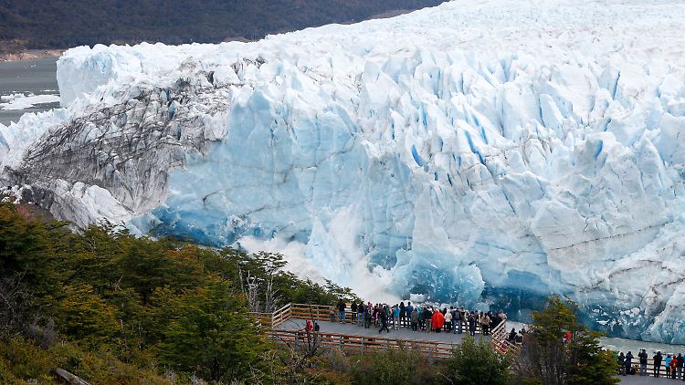 Menschen bestaunen den Perito-Moreno-Gletscher in Argentinien, als die Gletscherfront abbricht.