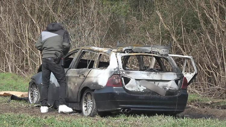 Die Polizei findet ein ausgebranntes Auto in der Nähe des Tatorts.