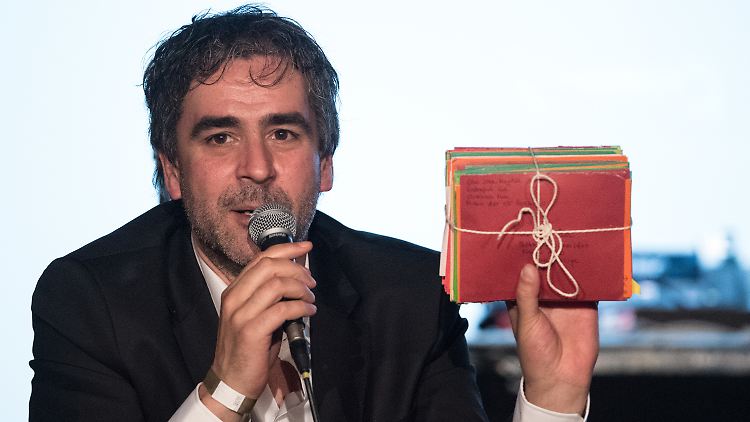 Yücel zeigt den Zuschauern in Paket Briefe, die ihm seine Frau Dilek mit ins Gefängnis gebracht hatte.