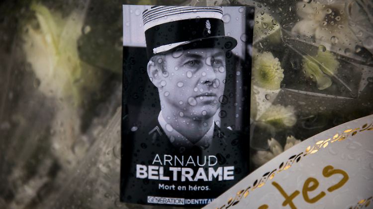 Ein Bild und Blumen erinnern in Carcassonne an Arnaud Beltrame.