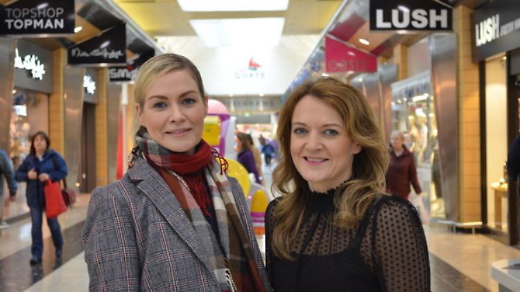 Die Schwestern Michelle (l) und Siobhan Reel im Shoppingcenter The Quays vor einem Schild ihrer Feinkost-Café-Kette.