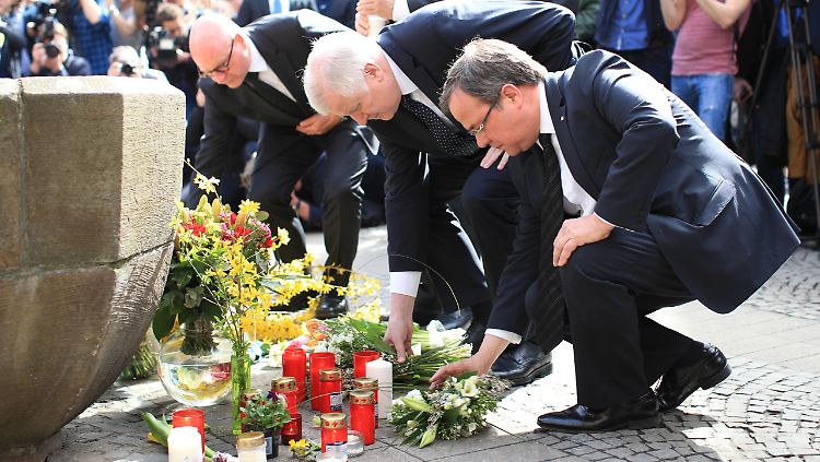 Markus Lewe, Oberbürgermeister von Münster, Bundesinnenminister Horst Seehofer und Armin Laschet, Ministerpräsident von Nordrhein-Westfalen, legen vor dem Brunnen an der Gaststätte "Kiepenkerl" Blumen nieder. 