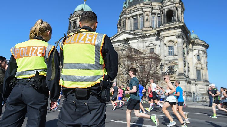 Polizisten stehen am Rande des Halbmarathons in Berlin.