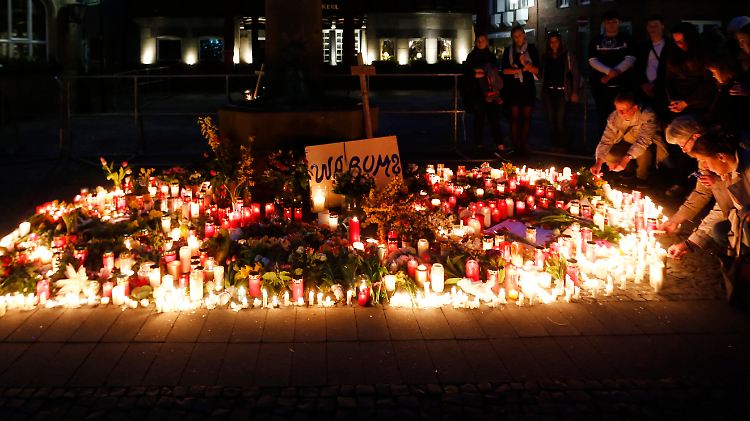 Menschen legen am Tatort in Münster Blumen und Kerzen für die Opfer der Amokfahrt nieder.