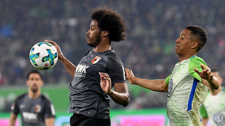 Wolfsburgs Ohis Felix Uduokhai (rechts) und Augsburgs Caiuby kämpfen um den Ball. Ein Tor schießt am Ende keines der Teams.