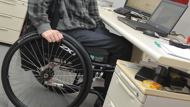 Ein Mann im Rollstuhl an seinem Arbeitsplatz.
