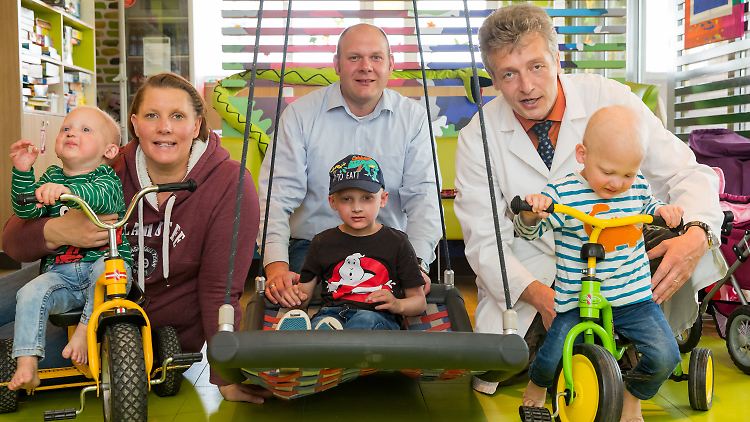 Corinna und Tobias mit ihren Kindern Joshua (M) und den Zwillingen Linus (l) und Maarten neben Holm Schneider, Arzt und Sprecher des Zentrums für Ektodermale Dysplasien Erlangen.