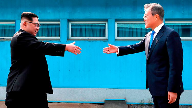 Große Gesten in der Militärsiedlung Panmunjom: Südkoreas Präsident Moon Jae-in und Nordkoreas Machthaber Kim Jong Un reichen sich über der Grenzlinie die Hände.