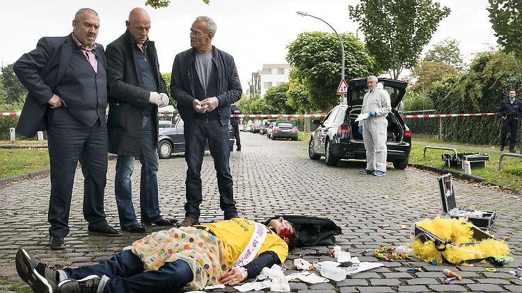 Die Kommissare Freddy Schenk und Max Ballauf und Rechtsmediziner Dr. Joseph Roth am Tatort neben einem Toten und einer Tasche voller Geld.