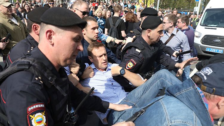 Der Oppositionspolitiker Alexej Nawalny wird von russischen Polizisten aus der Menge gezerrt.
