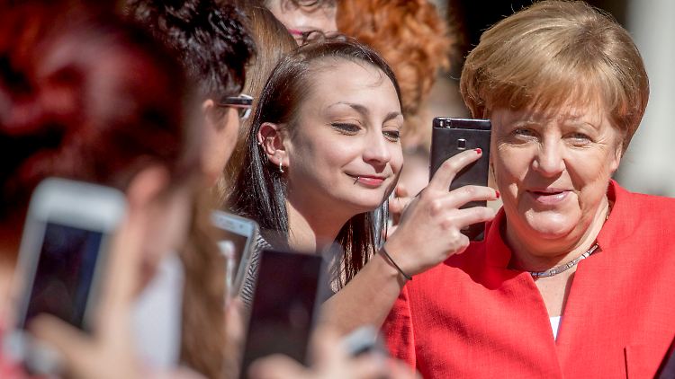 Freundlicher Empfang bei Sonnenschein: Merkel auf dem Schulhof der Jane-Addams-Oberschule.