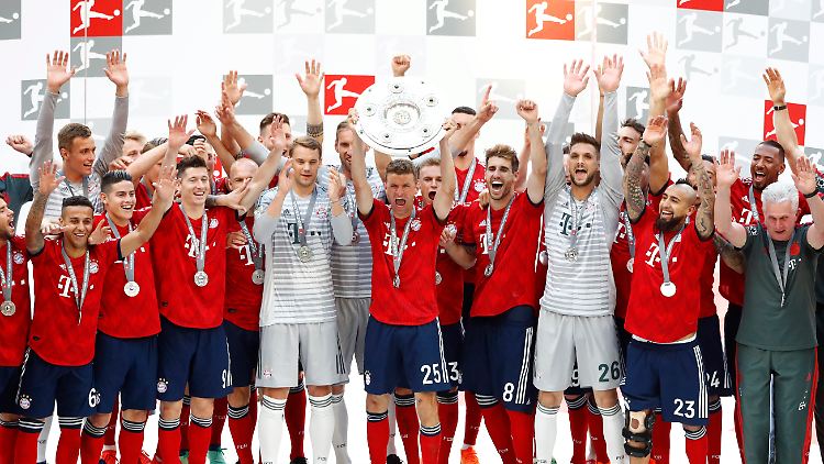 Gedämpfte Freude: Der FC Bayern mit der Meisterschale, die Kapitän und Dauerpatient Manuel Neuer in Empfang nahm.