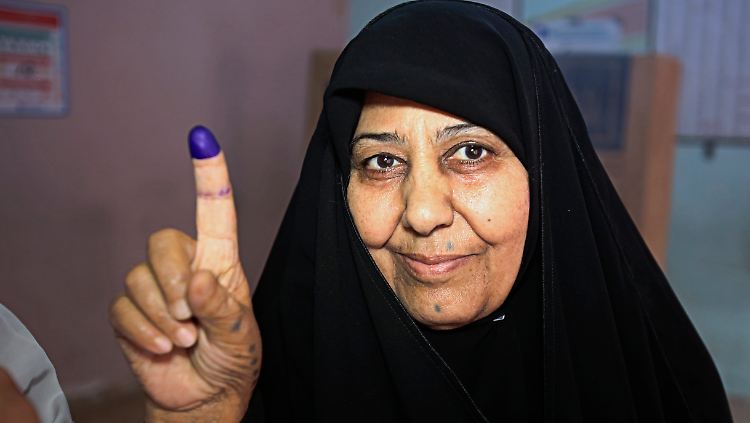Eine Frau in Bagdad zeigt mit einer Markierung am Finger, dass sie ihre Stimme abgegeben hat.