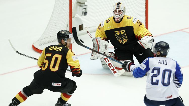 Finnlands Sebastian Aho (r.) versucht gegen Torwart Patrick Hager aus Deutschland und Mathias Niederberger ein Tor zu erzielen.