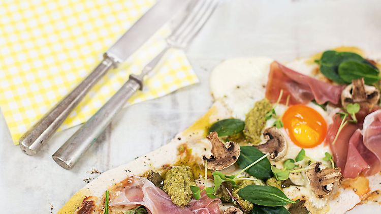 Frische Spinatblätter, Knoblauch, Champignons, Eier und Schinken veredeln diesen Flammkuchen.