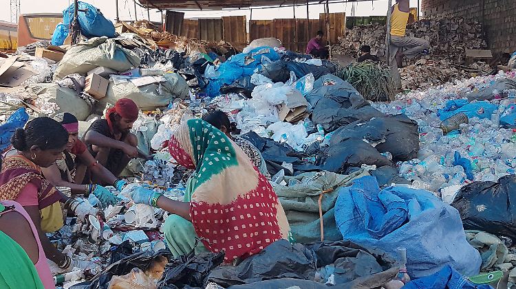 Am Rande von Neu-Delhi trennen Arbeiter eines Mülldepots den Plastikabfall per Hand.