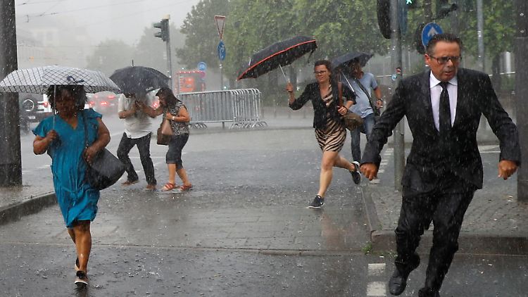 Menschen in Frankfurt suchen Schutz vor dem plötzlichen Starkregen.