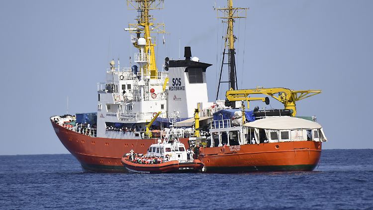 Ein Schiff der italienischen Küstenwache liegt am Rettungsschiff "Aquarius".