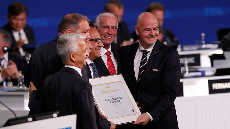 Fifa-Präsident Gianni Infantino (r) posiert nach der Erklärung, dass die WM 2026 in den USA, Mexiko und Kanada stattfinden wird.