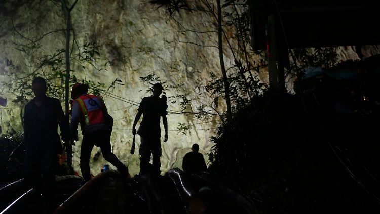 Rettungstaucher stehen am Eingang der Höhle.