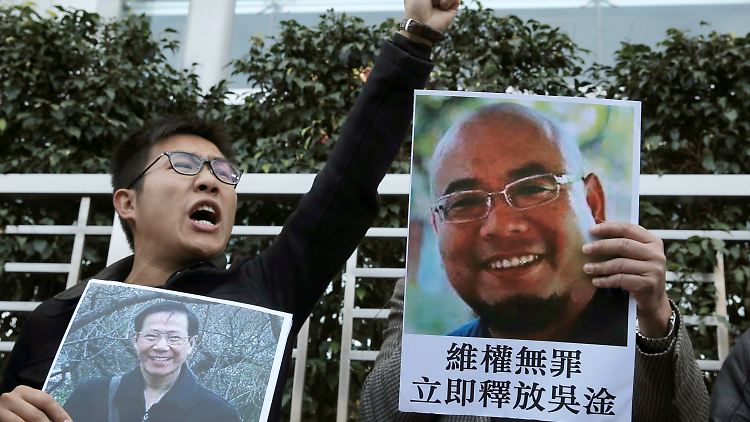 Demonstranten in Hongkong halten Fotos hoch, die die Regierungskritiker Qin Yongmin (l) und Wu Gan zeigen.