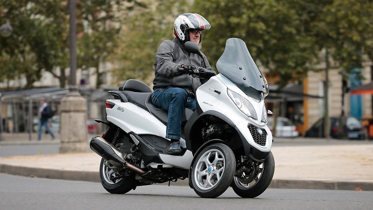 Im zähflüssigen Verkehr rund um den Pariser Triumphbogen keine Seltenheit: die Piaggio MP3.