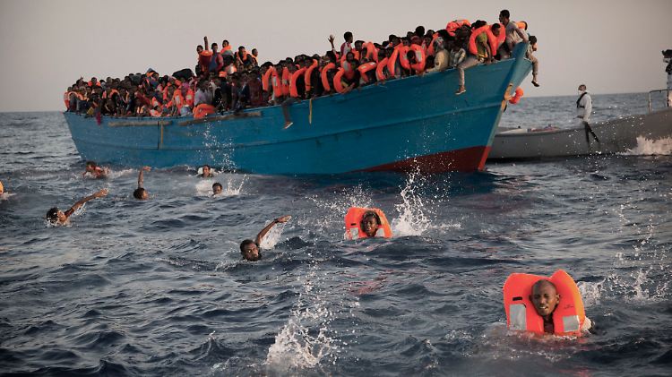 Flüchtlinge versuchen sich vor Libyen auf das Boot einer Hilfsorganisation zu retten.