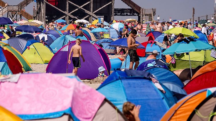 Sogar im sonst nicht so heißen Norden sehnen sich die Menschen nach Abkühlung. Dicht an dicht reihen sich die Strandmuscheln entlang des weitläufigen Strandes von Sankt Peter-Ording an der Nordseeküste.