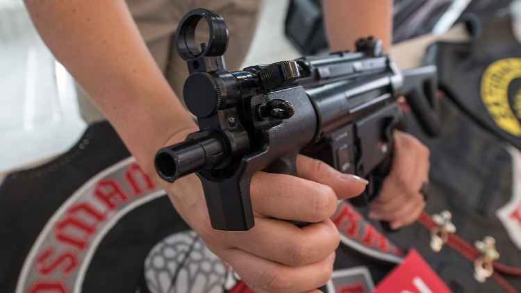 Eine Polizistin präsentiert eine bei Rockern beschlagnahmte CO2-Maschinenpistole.