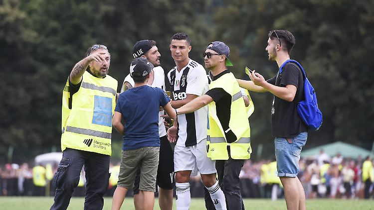 Gleich mehrfach stürmen Fans auf den Platz, um ein Bild mit Cristiano Ronaldo zu machen.