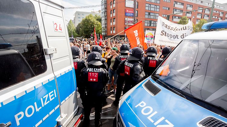 Gegendemonstranten stehen am Rande des Zuges der Neonazi-Demonstration anlässlich des 31. Todestages von Rudolf Heß.