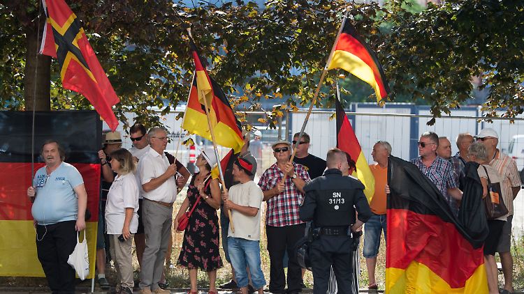 Teilnehmer einer Demonstration der islamfeindlichen Pegida-Bewegung empfangen Bundeskanzlerin Merkel.
