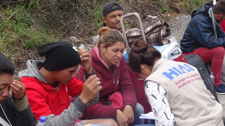 Eine Mitarbeiterin einer Hilfsorganisation spricht in Ecuador mit Flüchtlingen mit dem Ziel Peru.