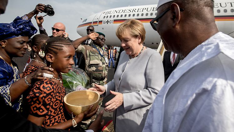 Auftakt eines Reisemarathon im Jahr 2016: Blumenmädchen und Staatspräsident Ibrahim Boubacar Keita (r.) begrüßen Kanzlerin Merkel in Mali.