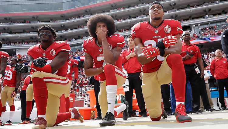 San Francisco 49ers Quarterback Colin Kaepernick (Mitte) kniet im Oktober 2016 zusammen mit Outside Linebacker Eli Harold und Safety Eric Reid vor dem Spiel gegen die Dallas Cowboys.