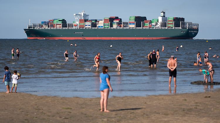 Urlaubsidylle am Strand von Cuxhaven-Döse: Vom Hamburger Hafen aus fahren Containerschiffe mit Exportwaren aus Deutschland in alle Welt.