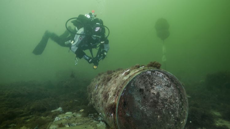 Heikle Mission - Eine Forschungstaucherin schwebt über einem gut erhaltenen Torpedokopf.