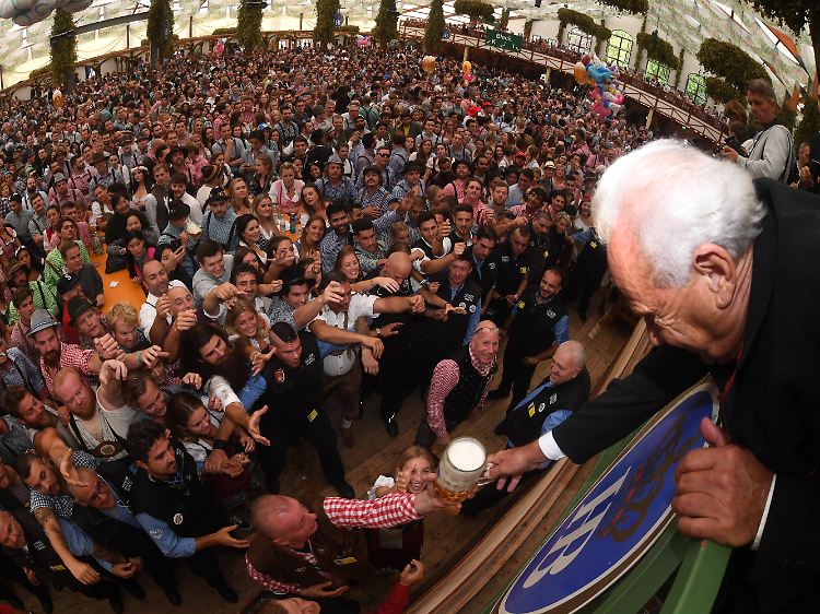 Das Bier steht für viele Oktoberfest-Besucher im Mittelpunkt: Im Hofbräuzelt reicht ein Wiesnwirt eine Maß Bier von der Bühne ins Publikum.