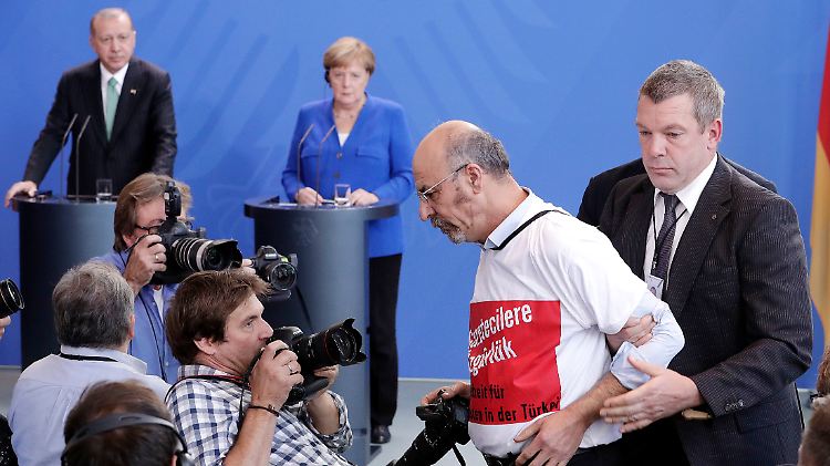 Ertugrul Yigit wird abgeführt. Auf seinem T-Shirt steht: "Freiheit für Journalisten"