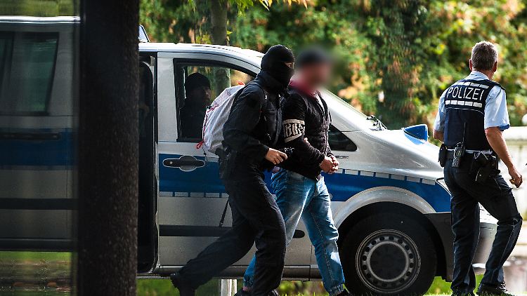 Einer der Verdächtigen wird von Polizisten zum Bundesgerichtshof gebracht. 