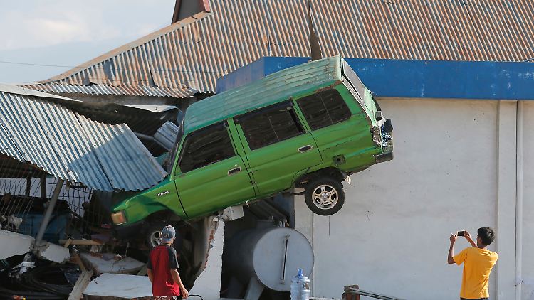 Ein Auto steckt infolge des Tsunamis im Dach eines eingestürzten Hauses fest (Palu, Sulawesi).