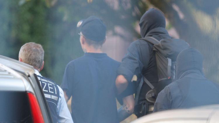 Ein Verdächtiger wird von Polizisten zum Bundesgerichtshof in Karlsruhe gebracht. 