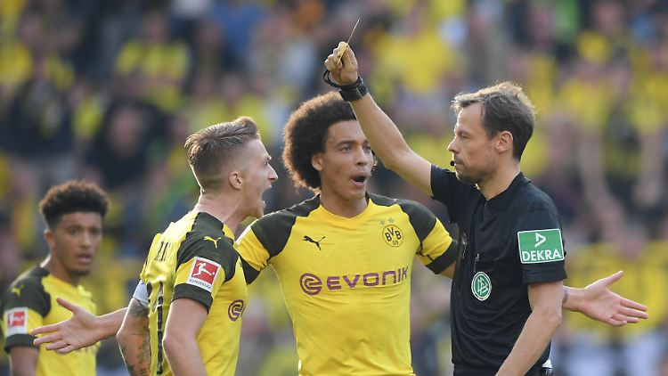 Dortmunds Kapitän Marco Reus (l.) beschwert sich bei Schiedsrichter Markus Schmidt über ein nicht geahndetes Foul und sieht dafür die Gelbe Karte.